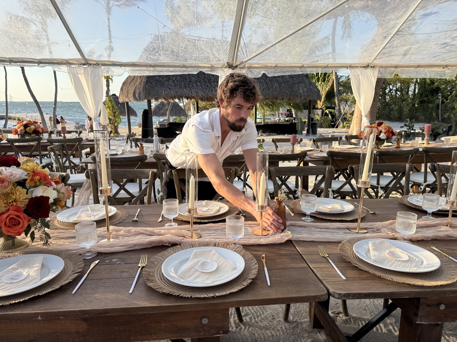 A Seaside Setups crew member arranging a waterfront wedding tablescape in the Florida Keys